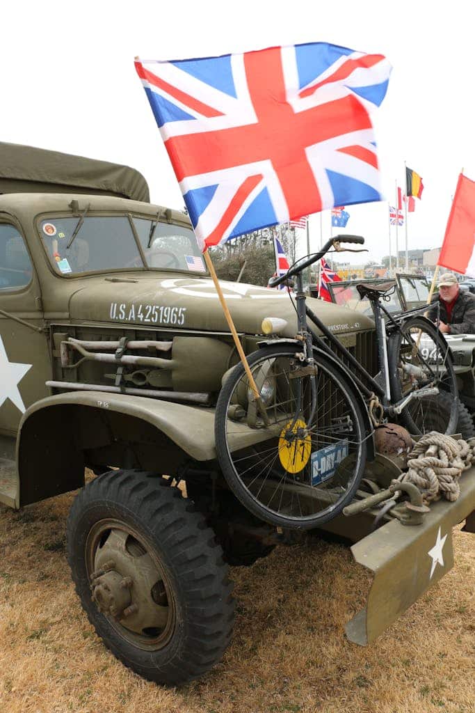 A vintage military truck with a British flag, commemorating WWII.