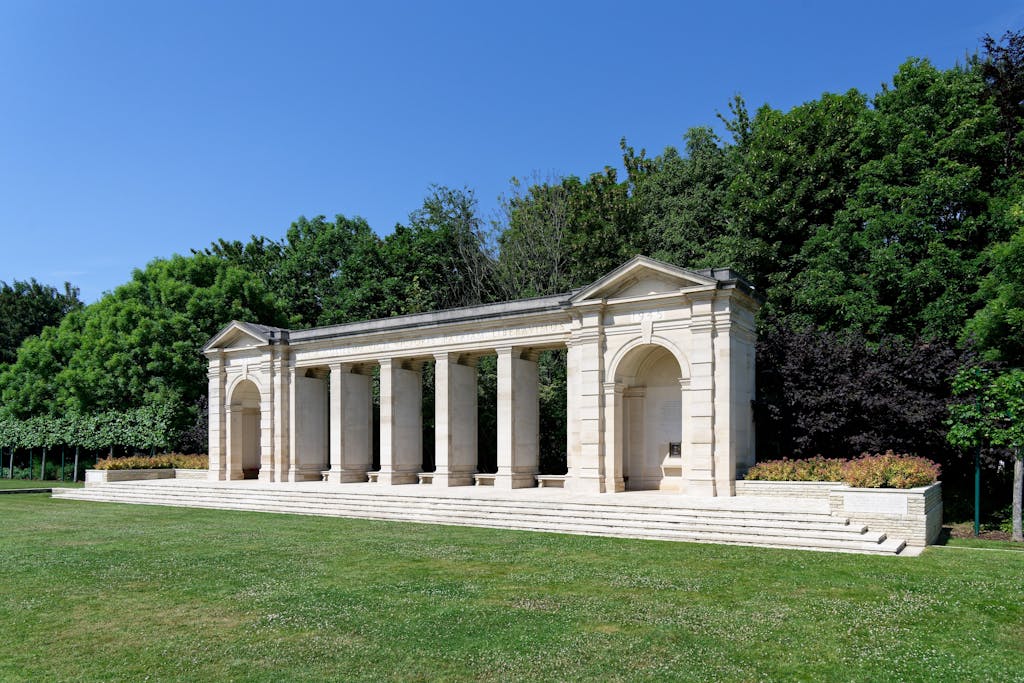 Explore this serene neoclassical memorial in Bayeux, Normandy, amidst lush greenery.