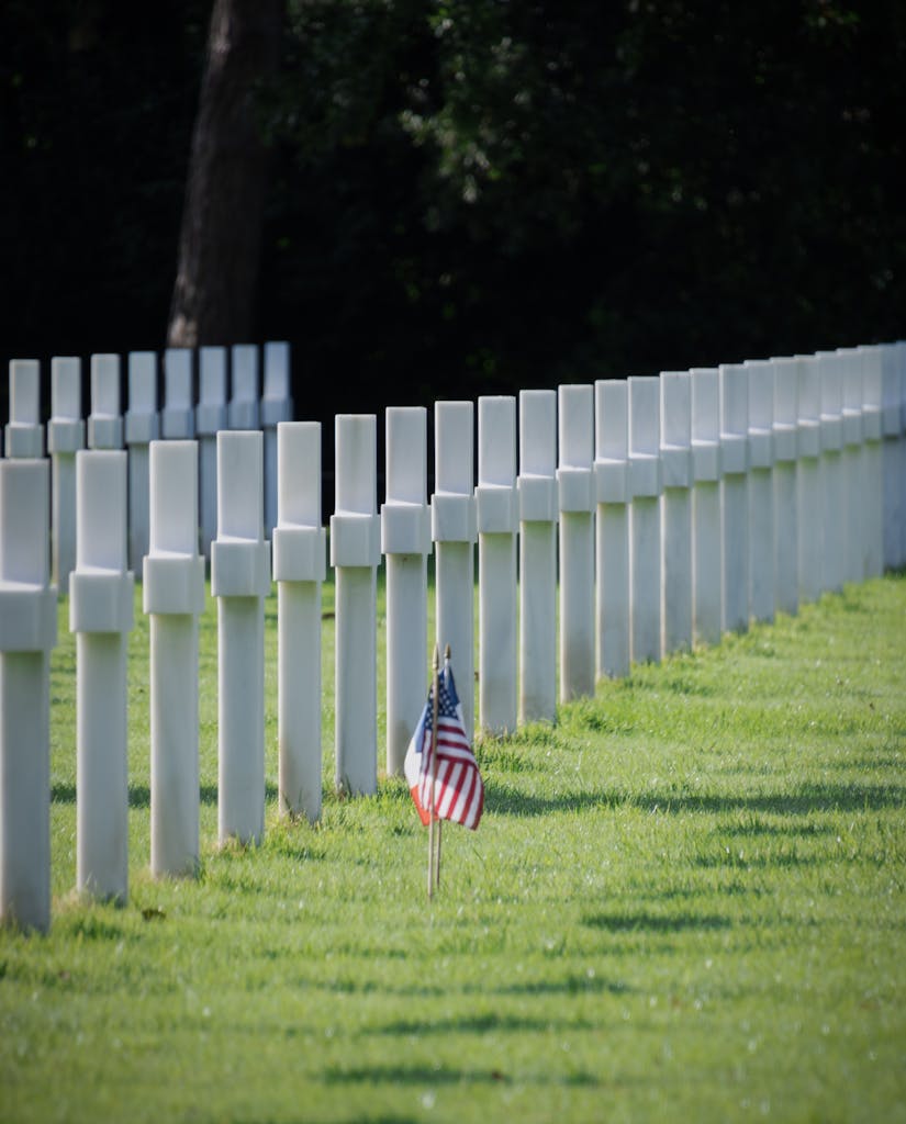 Flags adorn graves at the serene American Cemetery in Normandy, honoring fallen heroes.