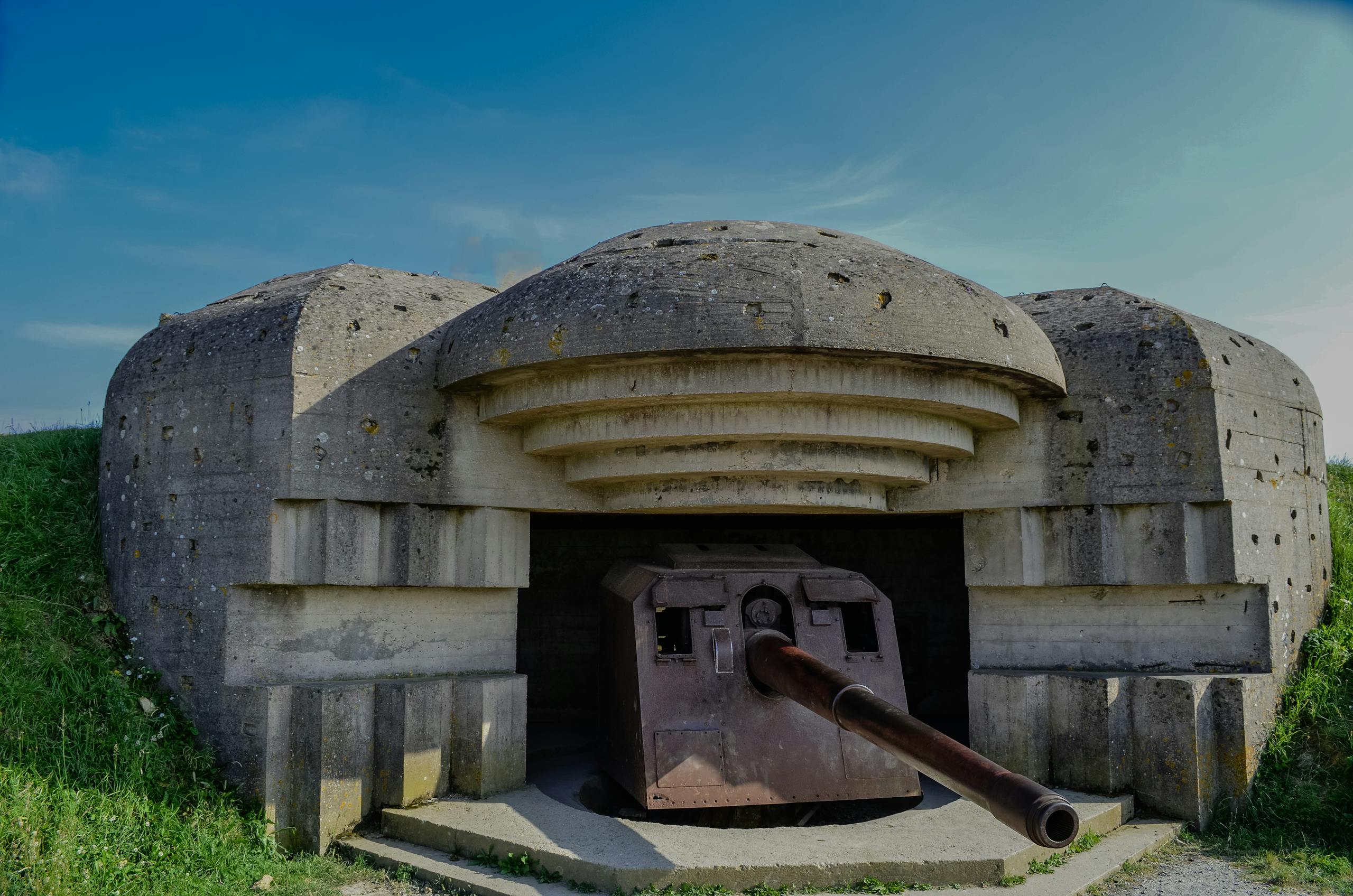 Historical World War II bunker located at Normandy, France with concrete fortification and gun turret.