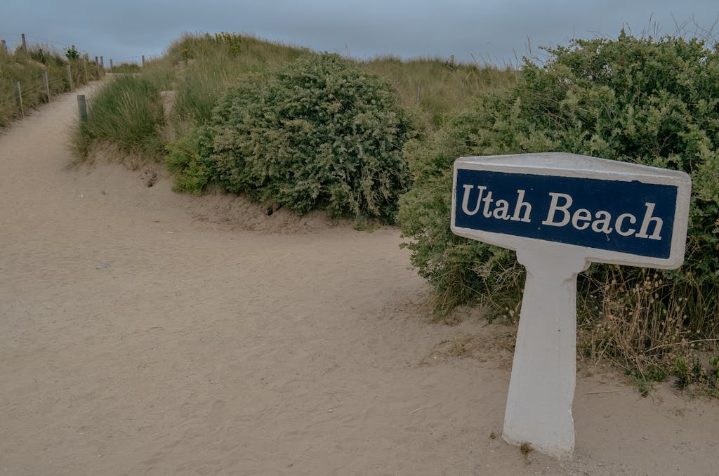 Pathway leading to Utah Beach in Normandy, marked by a distinct sign, famous for WWII history.