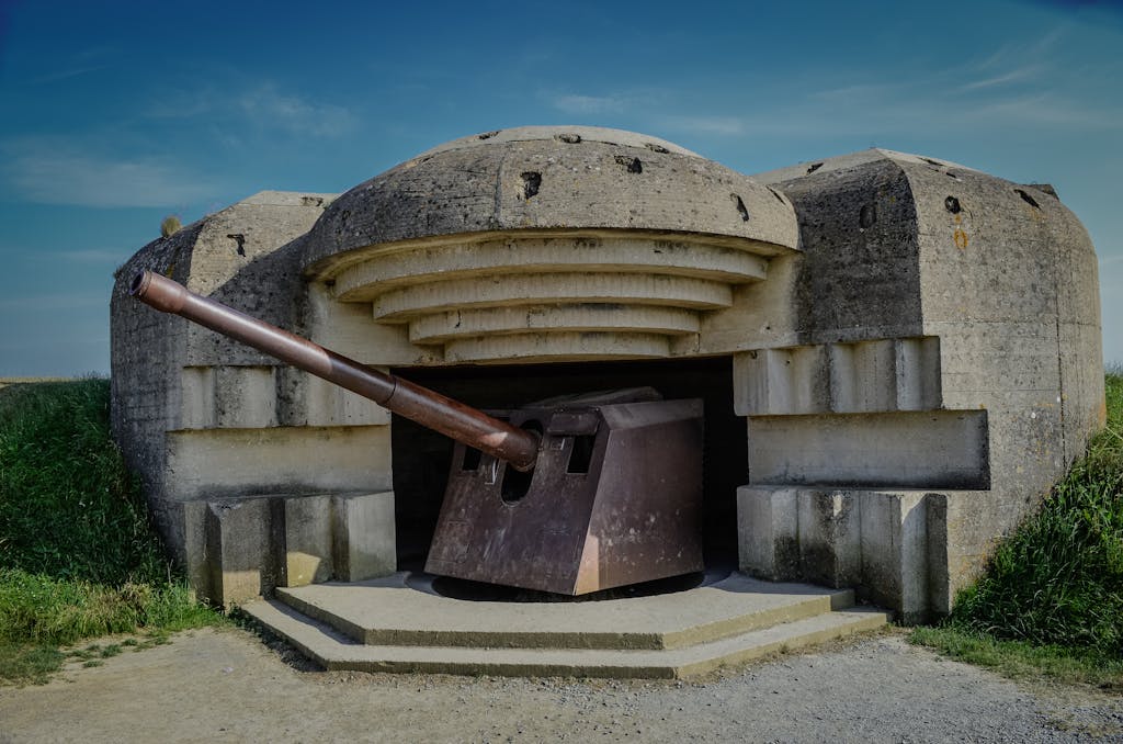 Photograph of a World War II bunker with a cannon in Normandy, France.