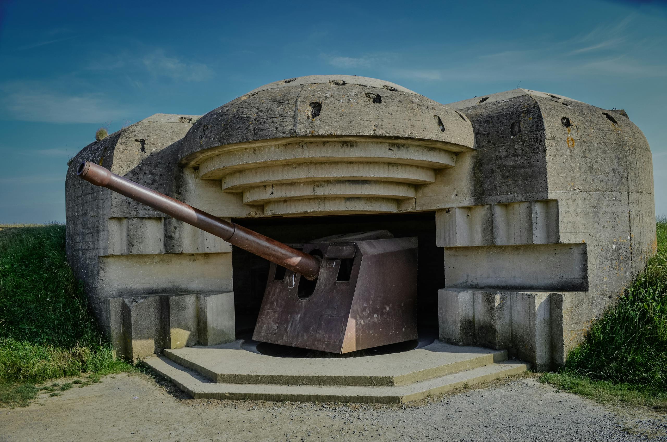 Photograph of a World War II bunker with a cannon in Normandy, France.