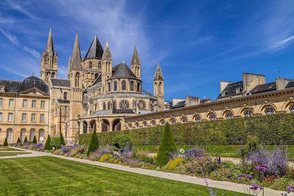 Stunning view of the historic Saint-Étienne Abbey in Caen, France, featuring lush gardens.