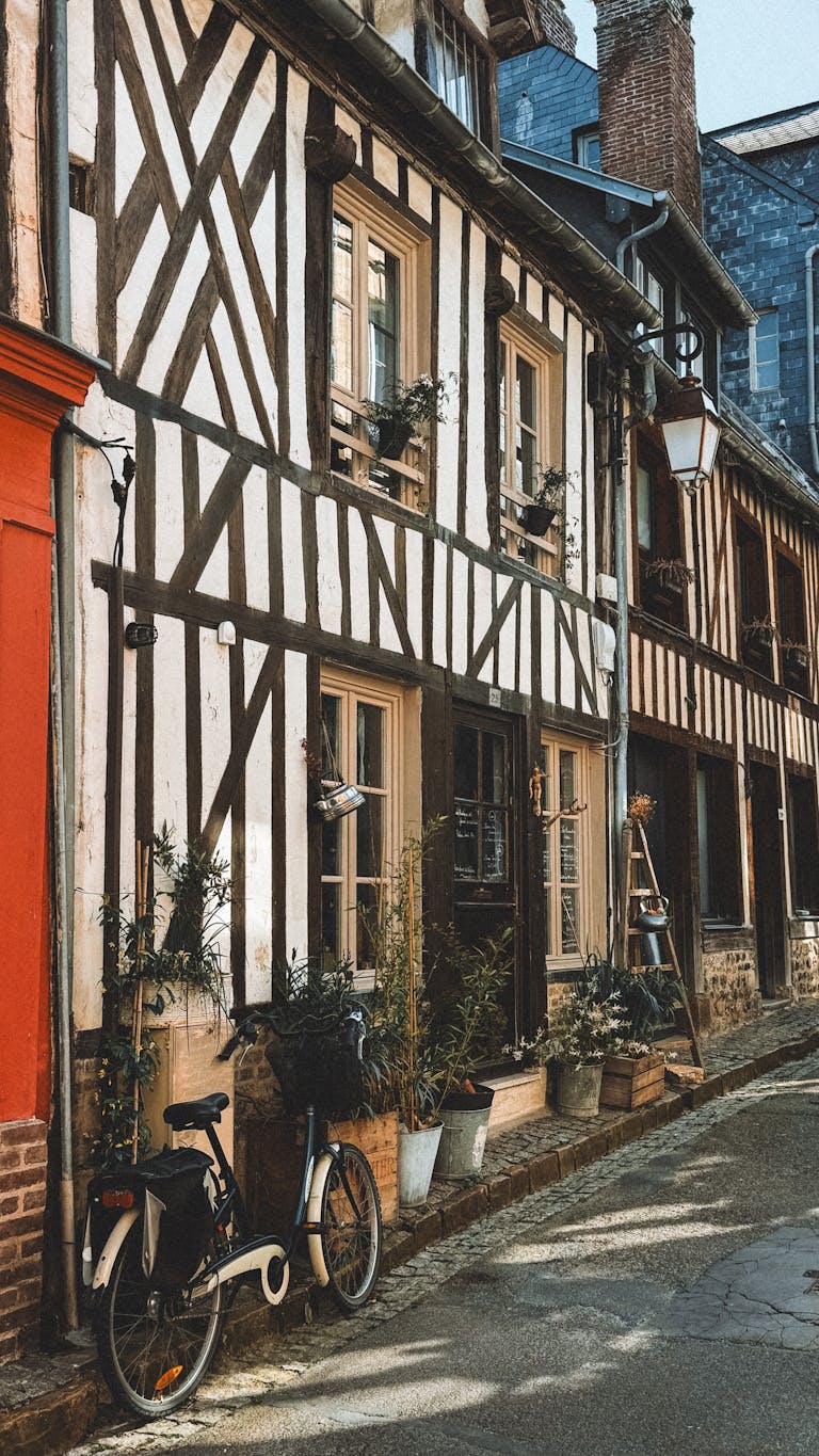 Historic half-timbered house with a bicycle on a quaint street. Perfect for travel and architecture themes.