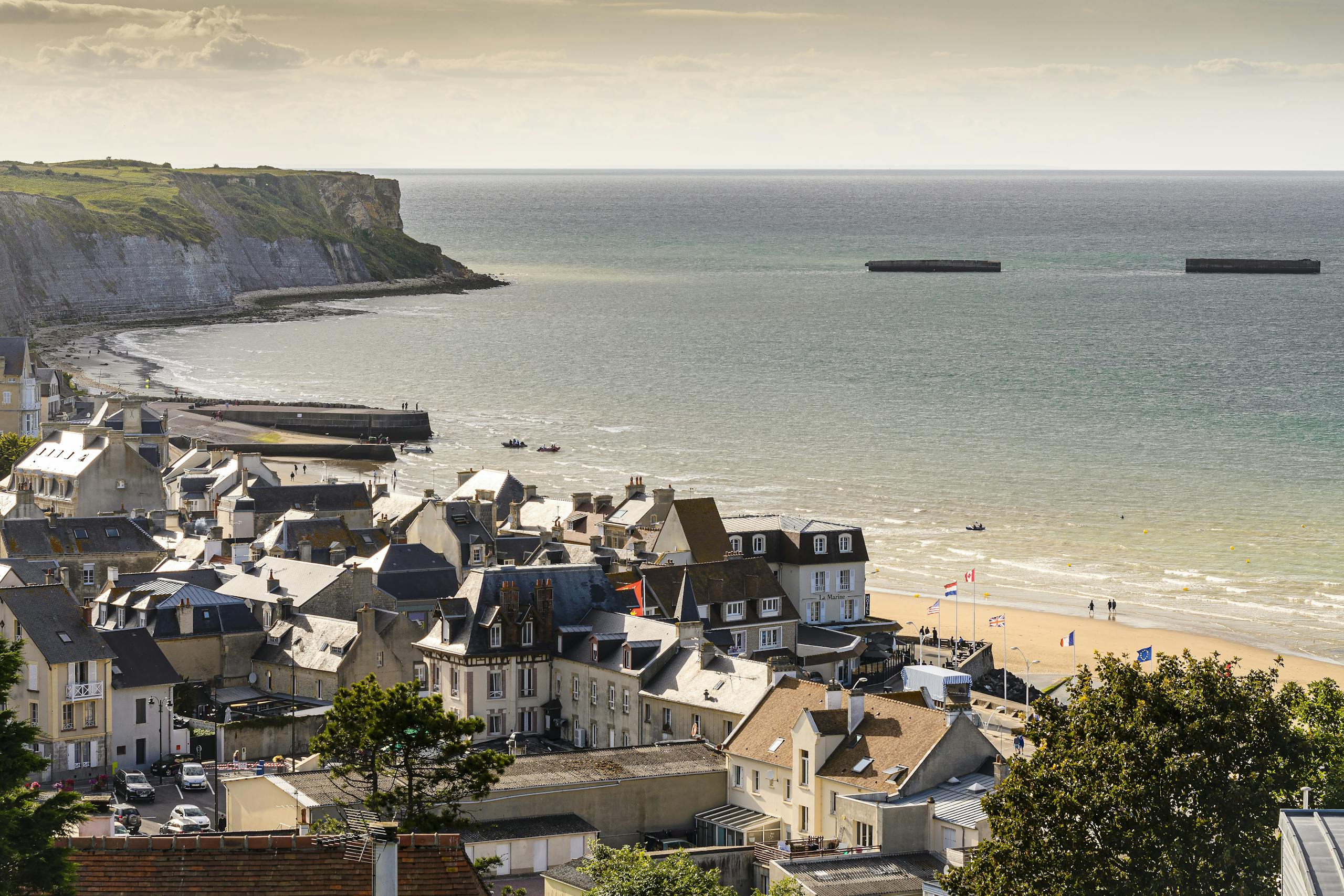 Historical World War II bunker located at Normandy, France with concrete fortification and gun turret.