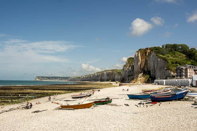 Scenic view of Yport beach with fishing boats and cliffs in Normandy, France.