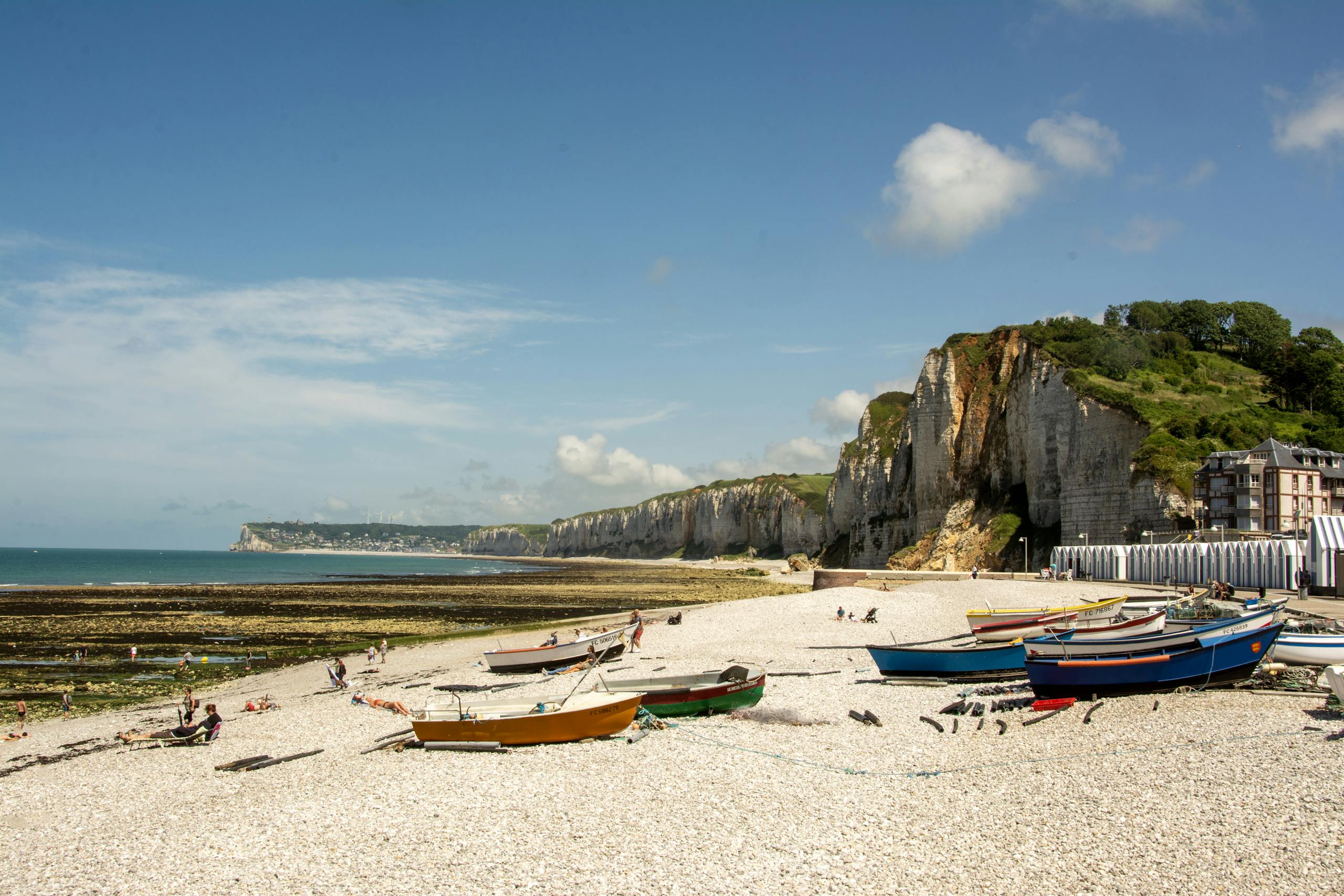 Scenic view of Yport beach with fishing boats and cliffs in Normandy, France.